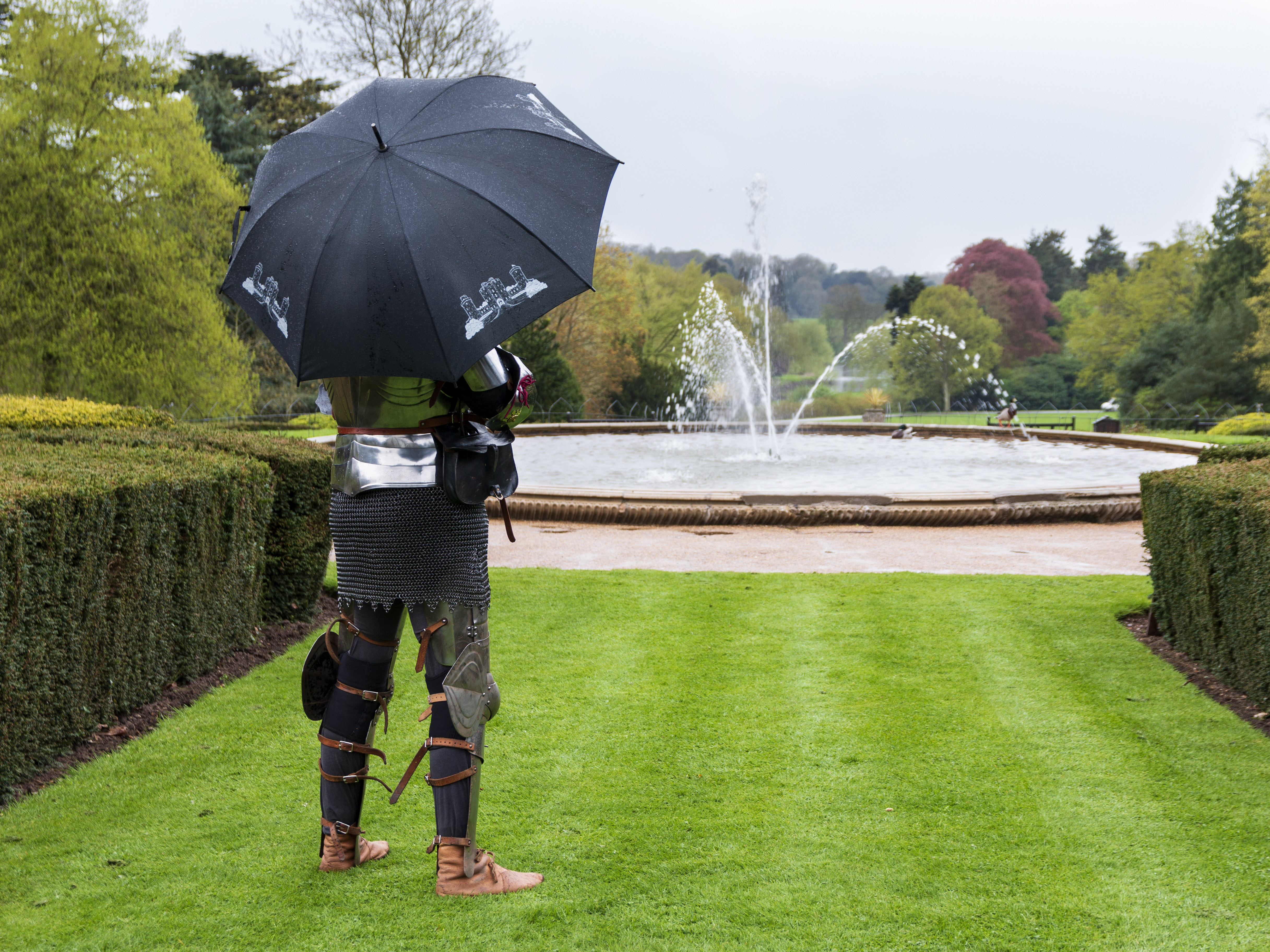 Knight under umbrella in gardens