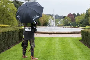 Knight under umbrella in gardens