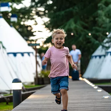 Boy running by tents