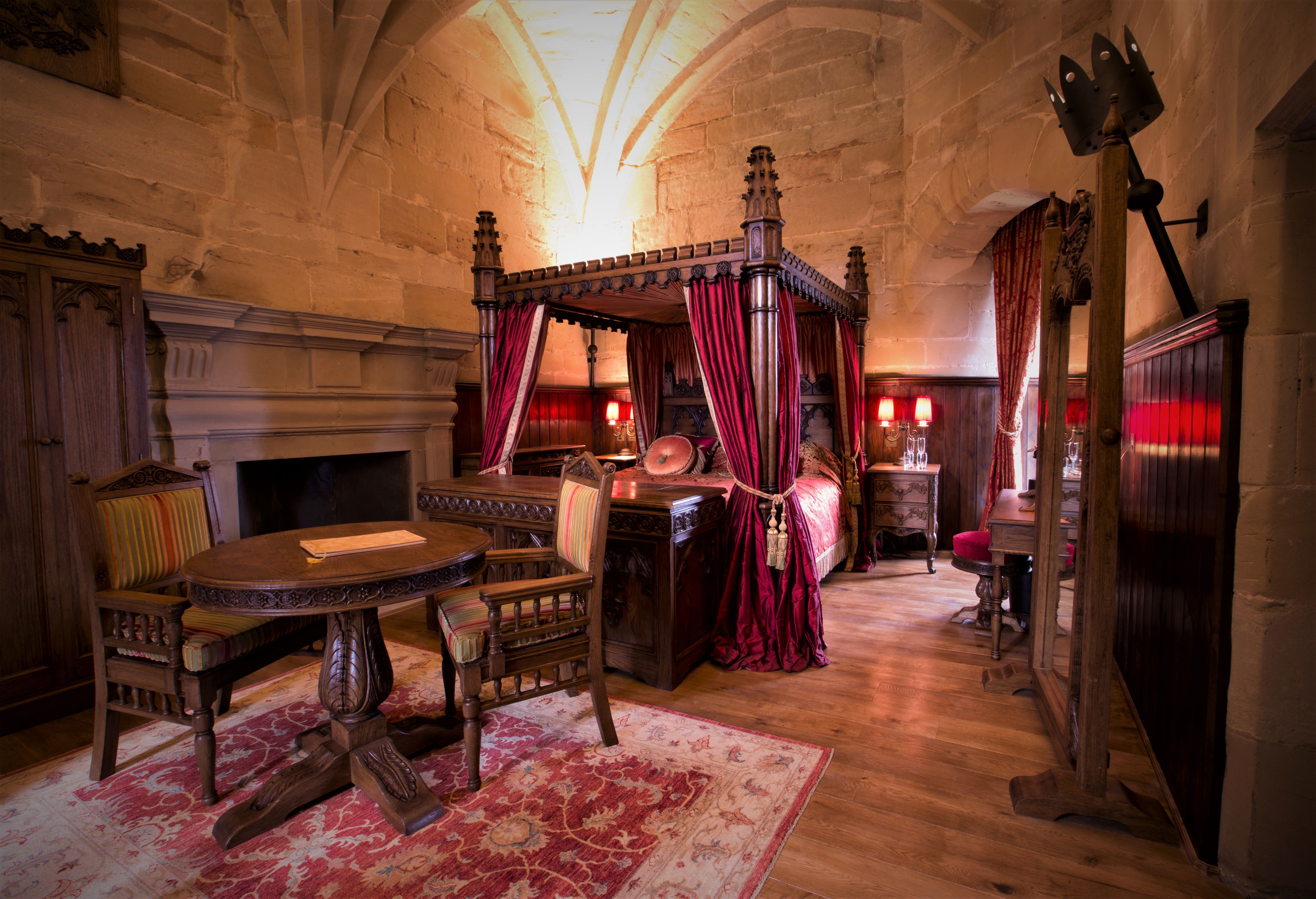 Caesar's Tower Suite interior at Warwick Castle showing the luxurious medieval four-poster bedroom
