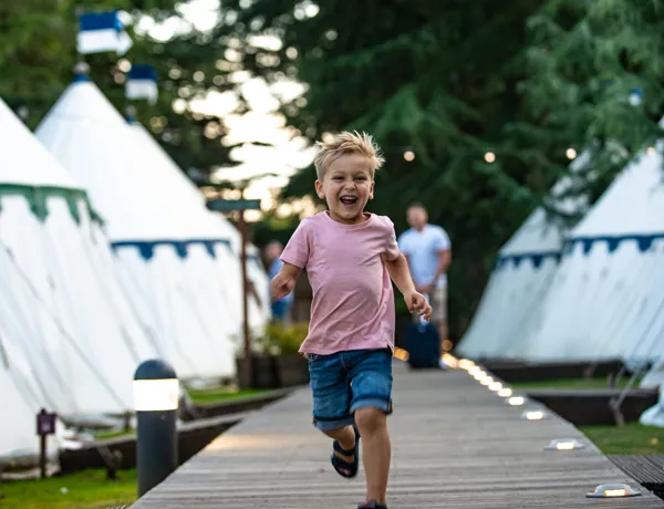 Boy running through tents 2